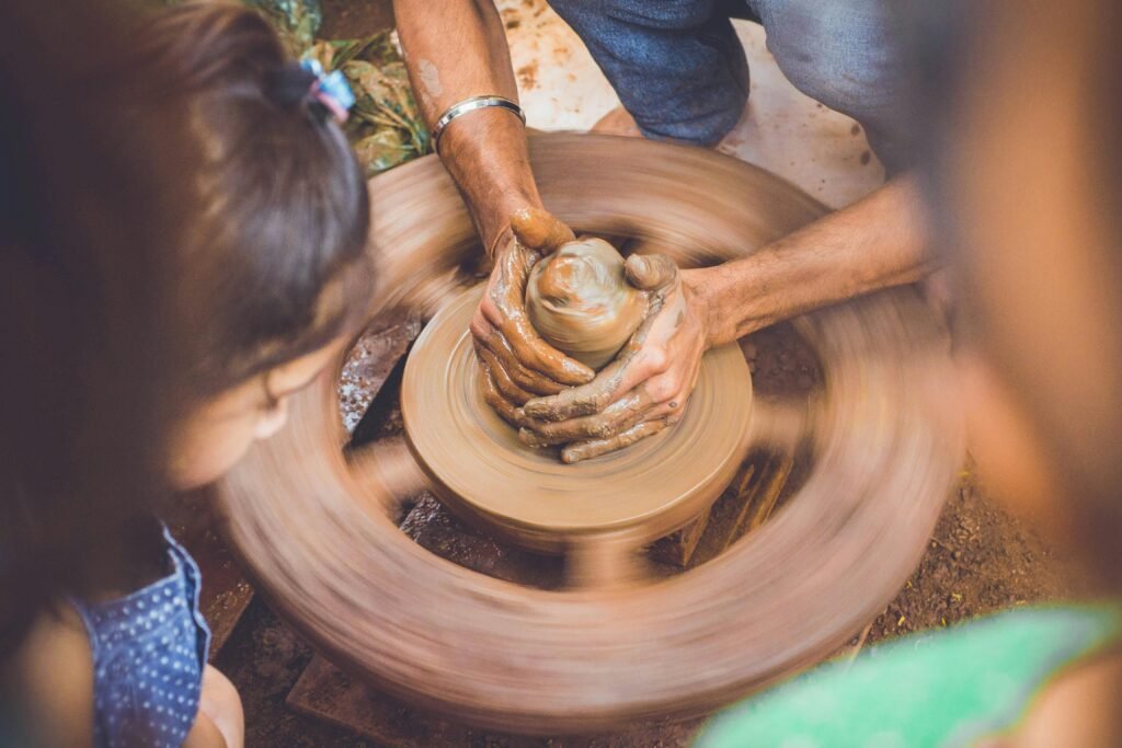 Close-up of hands shaping clay on a pottery wheel, capturing the artistry of crafting.